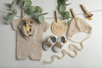 Baby clothes, shoes and accessories with washing line on light background, flat lay