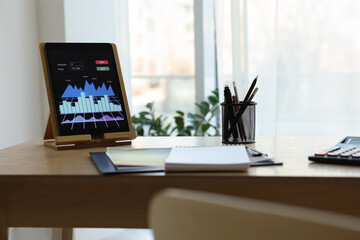 Workplace with tablet and stationery in office. Forex trading
