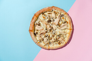 Pizza with Chicken fillet, champignon mushrooms, spinach, mozzarella and gouda cheeses with creamy sauce. blue pink background. Top view. Copy space