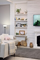 Cozy living room interior with comfortable sofa and decorative fireplace