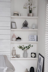 Wall shelves with beautiful decor elements indoors. Interior design