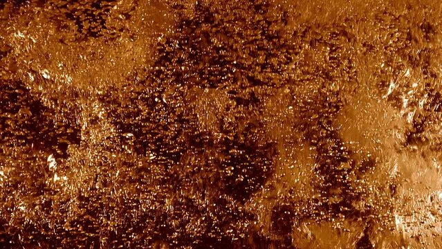 Golden orange beer bubbles swirling in a refreshing cool full-frame macro alcoholic beverage. 3D animation loop concept. Extreme close-up cut-in and cutaway shot of sparkling effervescent soda fizz.