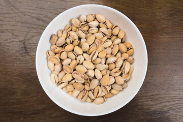 Salted pistachios in a white deep plate