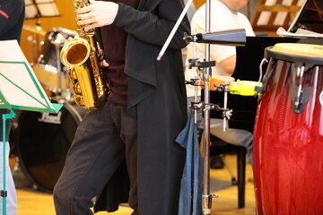 A saxophonist playing a musical instrument saxophone at a concert standing on stage