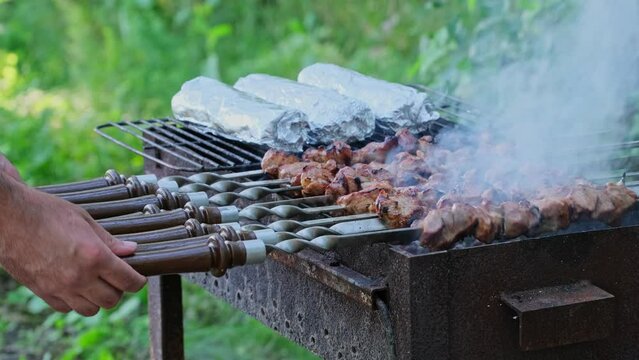 Pita in foil and Kebab cooking outdoors. Marinated barbecue meat in lavash cooked at barbecue. Street food. Grilled pork, meat lamb, shish kebabs, shashlik. Grill on charcoal and flame