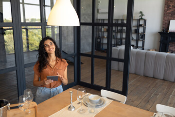 Modern technologies in daily life. Portraif of happy young woman using digital tablet at kitchen, copy space