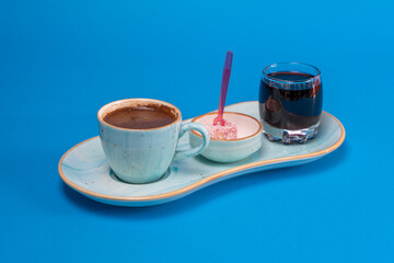 Image of Turkish Coffee, Turkish Delight and Turkish Cherry Sherbet taken with selective focus from opposite or side view on blue background in isolated area.