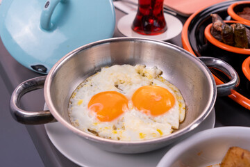 Cropped view of double-yolked scrambled egg and steel pot shot with selective focus from opposite or side view in isolated area.