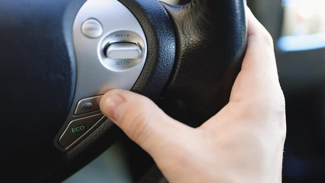 Finger press the button to start the autonomous cruise control autopilot. Steering wheel button the adaptive Cruise Control while driving a car. Transportation Concept