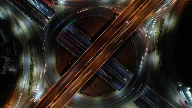 Hyperlapse time-lapse of car traffic transportation above circle roundabout road in Asian city. Drone aerial view fly in circle, high angle. Public transport or commuter city life concept