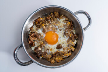 Close-up shot of scrambled eggs in an isolated setting from a top angle with selective focus on a gray background.