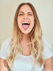 Lets be silly together. Portrait of an attractive young woman sticking out her tongue.