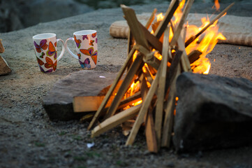 romantic evening by the fire, two cups and firewood