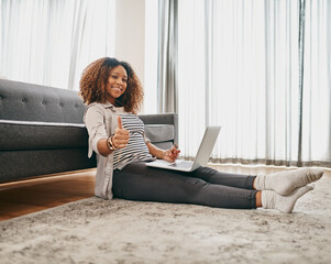 Obraz premium Ive bought all the things I need. Portrait of a cheerful young woman doing online shopping on her laptop while being seated on the floor at home.