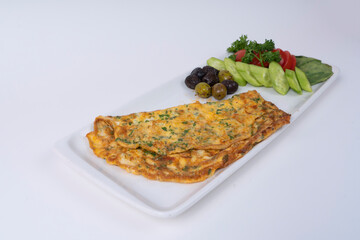 Cropped view of omelet with salad, olives and vegetables on white plate, shot with selective focus from counter angle on isolated area, gray background.