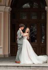 Obraz premium Beautiful bride and groom. Just merried. wedding couple.Close up. Happy bride and groom on their wedding hugging. Bride and groom at wedding near the old cathedral
