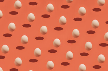 Easter season egg idea with visual pattern on festive orange background. Creative holiday and spring season concept, minimal food and shadow composition.