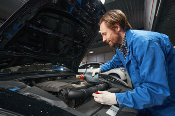 Fototapeta na wymiar Mechanic performing car maintenance at service station