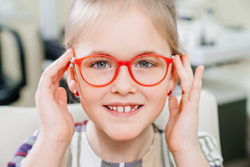 a pretty little girl in colored-rimmed glasses. glasses for children. 