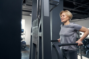 Cheerful woman in sportswear having workout in gym