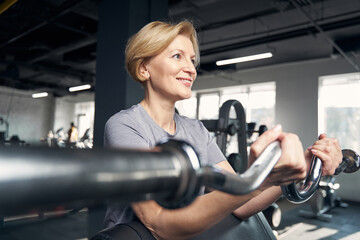Fototapeta premium Smiling woman doing exercise with gym trainer