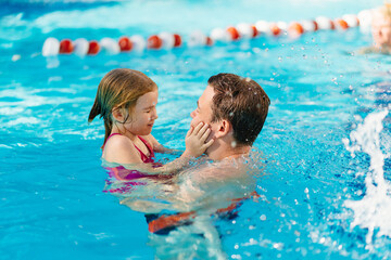 dad and daughter cuddle and swim in the pool. swimming training. 