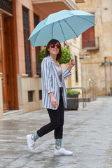 Woman walking down the street on a rainy day with umbrella