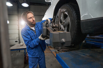 Worker performing car maintenance at service station