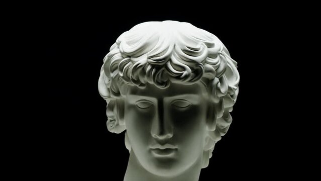 Plaster head sculpture Apollonian close-up. Gypsum ancient statue isolated on black background.