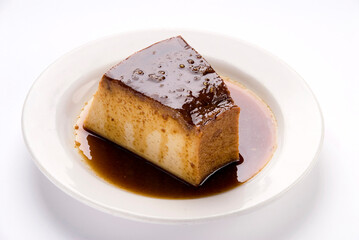 Neapolitan flan on a white background, slice of pudding dessert with caramel sauce