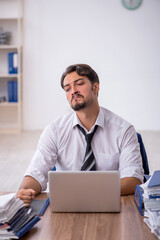 Young male employee and too much work in the office