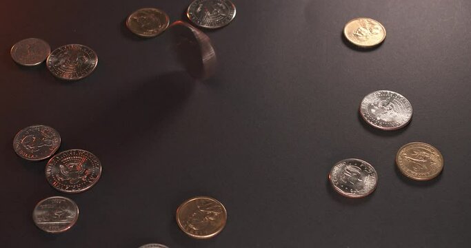 Eisenhower Dollar spinning next to shiny Half Dollar coins. US Money on dark surface.