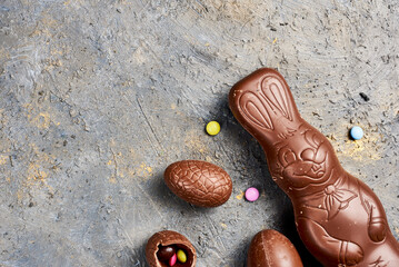 Chocolate Easter bunny and eggs on wooden background