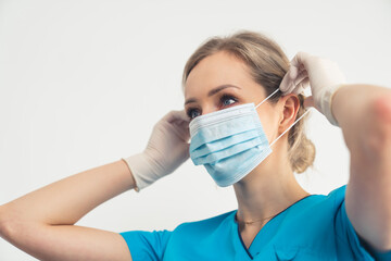 Responsible Nurse Putting On Medical Face Mask. Protection from bacteria and viruses. High quality...