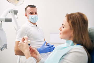 Dentist discussing dental treatment with woman in clinic