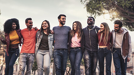 Multiethnic group of people standing together and walking outdoors arm on shoulders in the nature - concept of diverse people connection, togetherness and internationalization