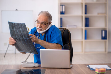 Old male doctor radiologist working in the clinic