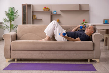 Old man doing sport exercises at home