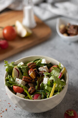 Salad with herbs and fruits on a light background close-up