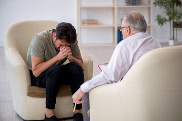 Obraz premium Young man visiting old psychologist