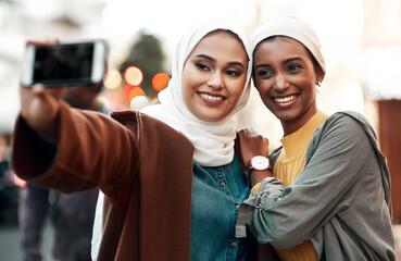 Selfie time. Cropped shot of two attractive young women standing together and wearing headscarves...