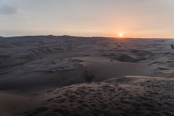 The sun setting over the dunes at Huacachina, Peru. 