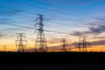 In the evening, the silhouette of high voltage towers