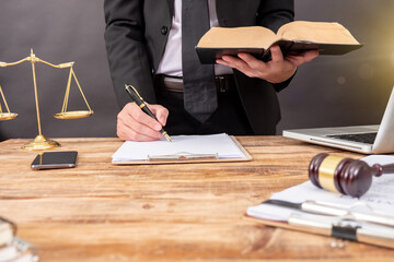 justice and law concept. Male judge in a courtroom with the gavel, working with, digital tablet computer docking keyboard, eyeglasses