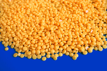 pile of hard wax beans over a blue chroma key background representing orange lentils or healthy seeds