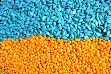 hard wax beans with different sizes, shapes, textures and formats and the colors of the Ukrainian flag in yellow and blue seen from above
