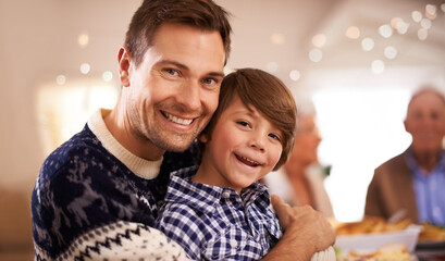 Christmas time is a tradition in this home. Portrait of a young father and his son on Christmas day.