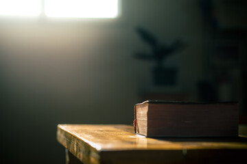 Close up holy bible with light in morning on wooden table, christian concept.