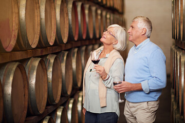 Theyve got a cellar full of wine. Cropped shot of an affectionate senior couple wine tasting in a cellar. - Powered by Adobe
