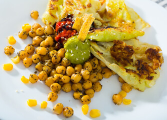 Photography of plate with cabbage leaves in batter with garbanzos and sauce in restaurante.